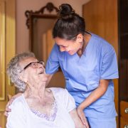 Happy Senior woman laughing with her caregiver at home. Senior